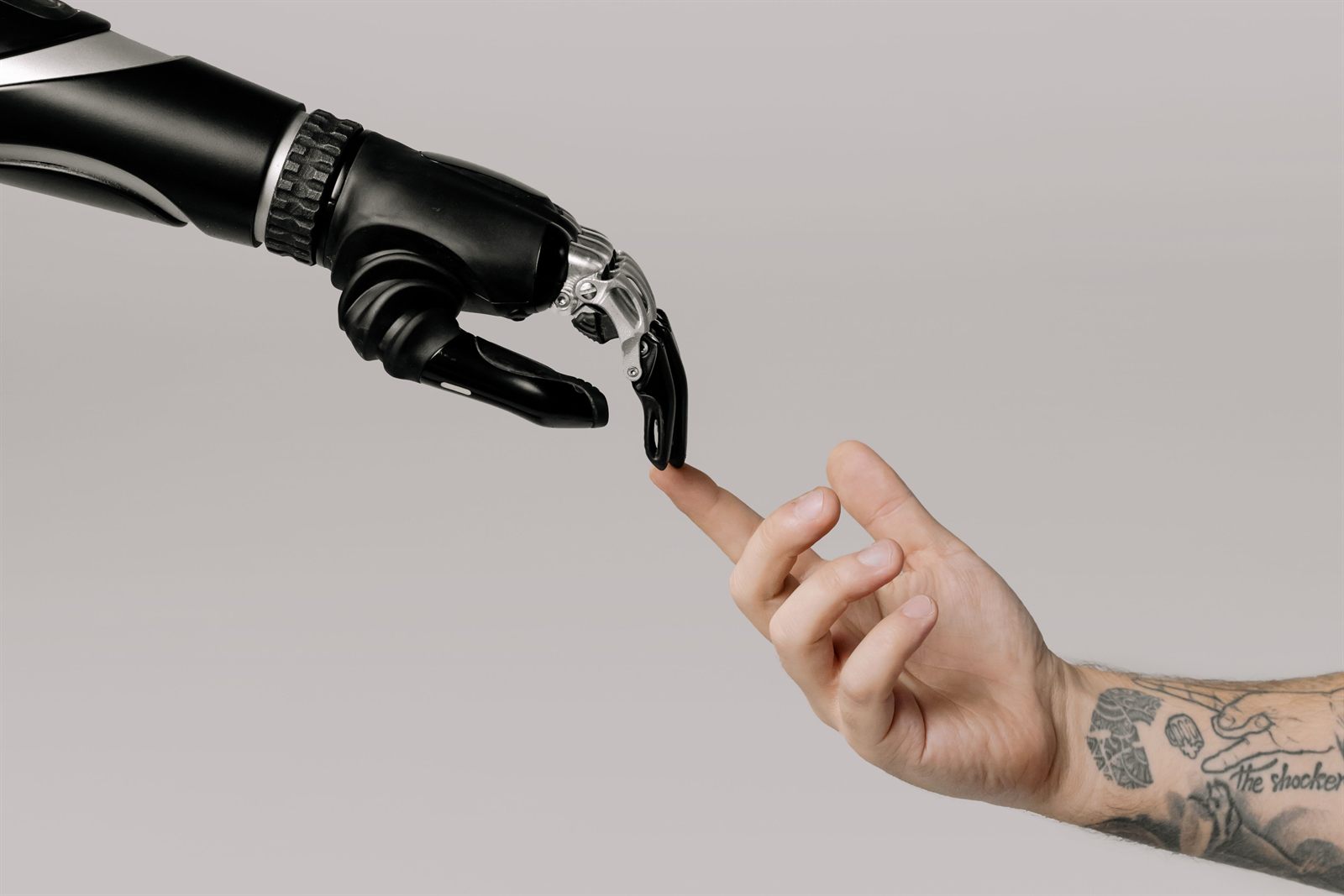 A robotic hand and a human hand reaching toward one another